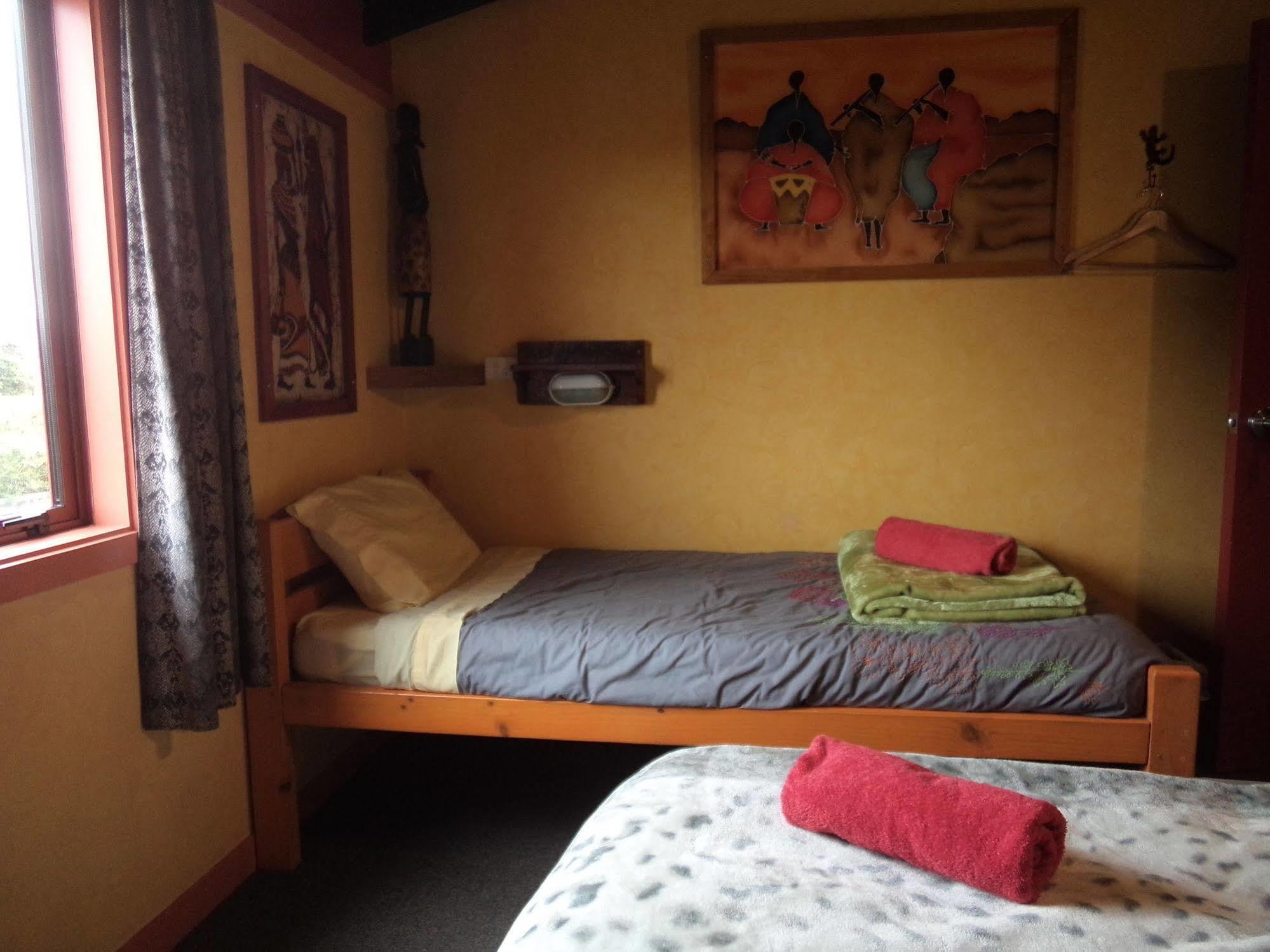 グローバル ビレッジ トラベラーズ ロッジ グレイマウス エクステリア 写真 A single bed in a hostel room